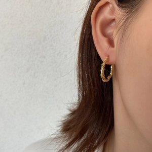 925 silver gold braided twist hoop earring worn by a model in a minimalist French style