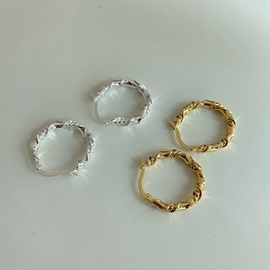 Macro shot of twisted hoop earrings in gold and silver finish with S925 hallmark