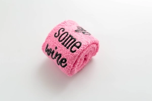 Detail of pink coral fleece socks featuring black embroidered 'some wine' text