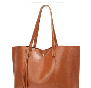 Close-up of brown oil wax leather bucket bag with fringe tassel and large capacity detail