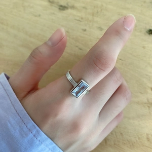 Detailed close-up of a 925 silver ring featuring a rectangular blue zircon on a finger