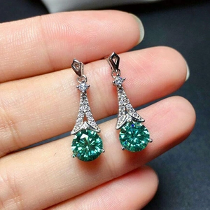 Detailed close-up of sterling silver drop earrings with round green moissanite main stones
