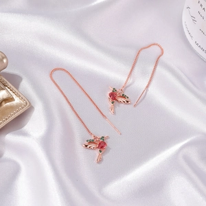 Detail of hummingbird threader earrings in rose gold with red and green stones