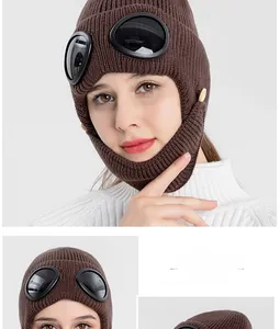 Close-up of dark brown knit aviator hat with goggles and button fastening detail