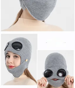Close-up of grey knit aviator balaclava with integrated goggles and wood button details