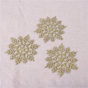 Detailed view of three golden glitter snowflake ornaments for Christmas tree decoration