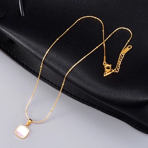 Detailed macro view of 18K gold chain with white mother of pearl square pendant and K18 hallmark