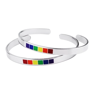 Detail of two C-shaped stainless steel bracelets with colorful rainbow enamel inlay