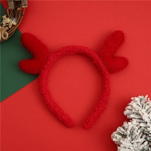 Christmas reindeer antler headband made of plush fleece on a festive red background