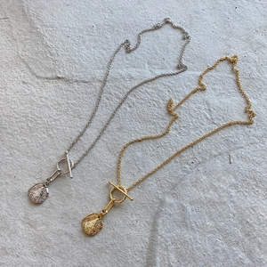 Detail of irregular lava coin necklaces in gold and silver with T-bar toggle clasp