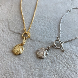 Close-up of minimalist gold and silver 925 sterling silver necklaces with OT buckle clasp