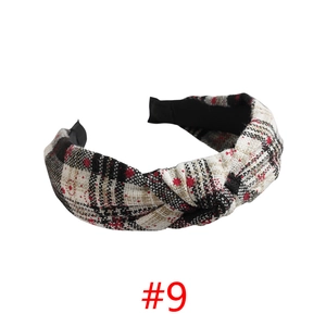 Close-up of knotted Christmas headband with black, white, and red plaid fabric texture