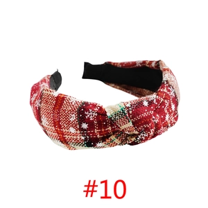 Detail of red plaid Christmas headband with white snowflake patterns and knot design
