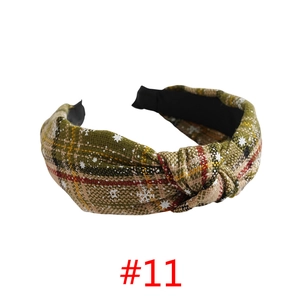 Close-up of green and red plaid fabric headband with white snowflake patterns and knot detail