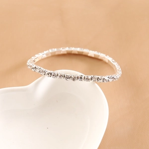 Close-up of a silver multi-layer rhinestone bracelet on a white heart-shaped plate