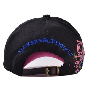 Dettagli del ricamo a farfalla e cinturino in pelle su un cappellino da baseball nero