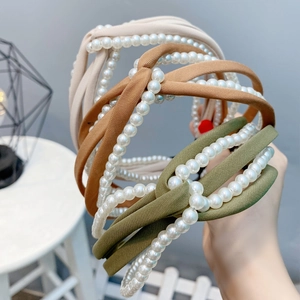 Close-up of twisted chiffon headbands with white pearl accents in beige, brown and green