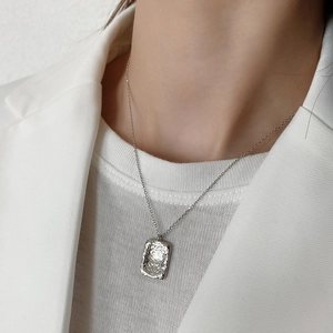 Detail of minimalist 925 silver hammered rectangle pendant on a female model