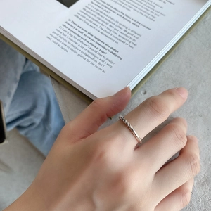 Detailed view of a 925 sterling silver twisted rope ring worn on finger for daily style