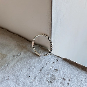Detail of S925 sterling silver ring showing polished surface and twisted rope texture