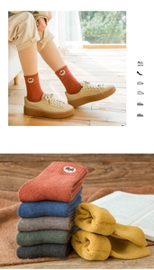 Macro detail of thick winter crew socks with cute bear embroidery in vibrant colors