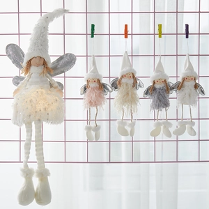 Christmas plush angel ornaments with glitter wings and hats on a pink mesh display rack