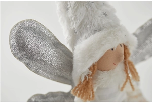 Detailed macro view of white plush Christmas angel doll with silver glitter wings