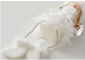 Macro shot of white plush angel ornament with feather wings and soft texture details