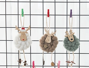 Detailed view of handmade wool felt reindeer ornaments in three colors on a mesh display