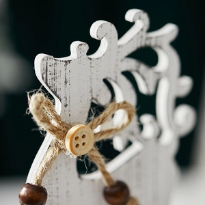 White wooden Christmas reindeer desk ornament with rustic twine bow and hanging bead detail