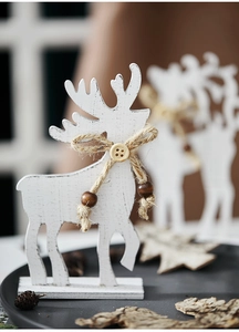 Close-up of a white wooden Christmas reindeer with jute rope and beads on a stand