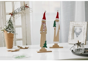 Hand-painted wooden Christmas tree ornaments with snowman and Santa figures on a desk