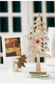 Macro detail of wooden Christmas tree tabletop decor with owl motif and snowflake pattern