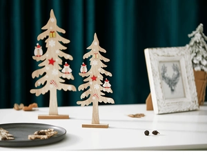Detailed view of two wooden Christmas tree ornaments with painted owls on white surface
