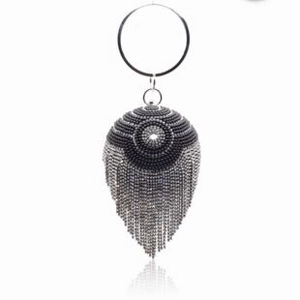 Detail of spherical evening clutch with silver tassels and round metal handle grip