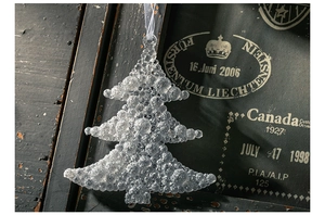 Funkelnder Weihnachtsbaumanhänger aus Acryl mit Glitzereffekt vor Vintage-Hintergrund