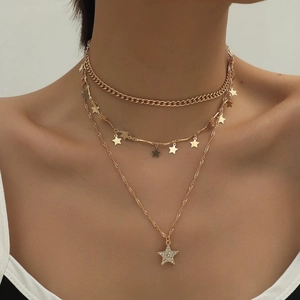 Detail of layered gold hip-hop chain necklace with cubic zirconia star pendants