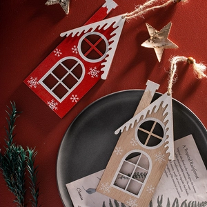 Hand-painted wooden Christmas house ornaments with white snowflakes on dark ceramic plate