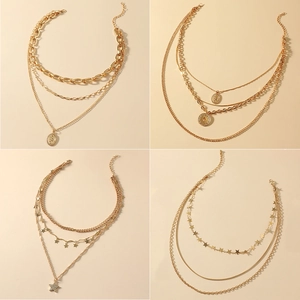 Gold multi-layer hip-hop necklaces with star and coin pendants on beige background
