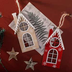 Handcrafted wooden Christmas house ornaments with white snowflakes on red background