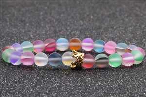 Macro shot of colorful matte moonstone beads featuring a gold crystal crown charm