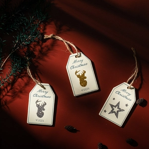 Christmas gift tags with gold reindeer and silver star patterns on dark red background