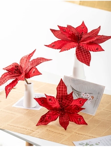 Macro shot of large red artificial Christmas poinsettia with shimmering glitter and sequins