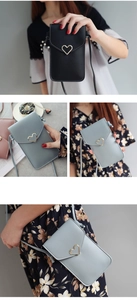 Détail d'un petit sac de téléphone avec fermoir en métal en forme de cœur et similicuir