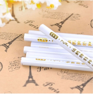 Macro shot of white nail art picker pencils with gold numbering on vintage paper