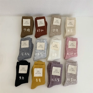 Matrix display of twelve colorful rib-knit wool blend socks with branded tags
