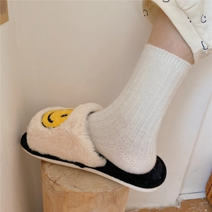 Plush beige slippers with yellow smiley face embroidery and black sole for home