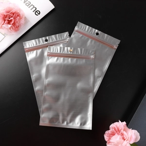 Three premium matte silver aluminum foil ziplock bags with hang holes on dark background