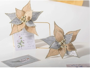 Macro detail of artificial burlap poinsettia with silver sequins and gold beads for decor