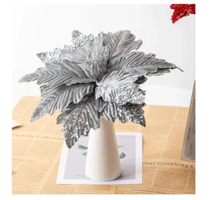 Macro shot of silver sequined artificial poinsettia flower in a white ceramic vase